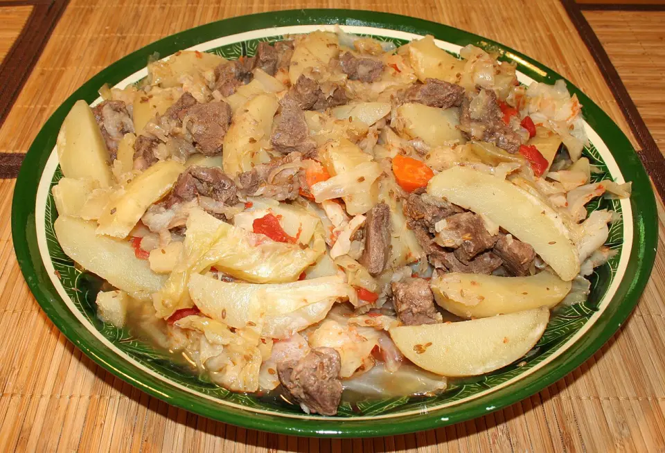 A platter of dimlama with meat, potatoes, cabbage, carrots and peppers