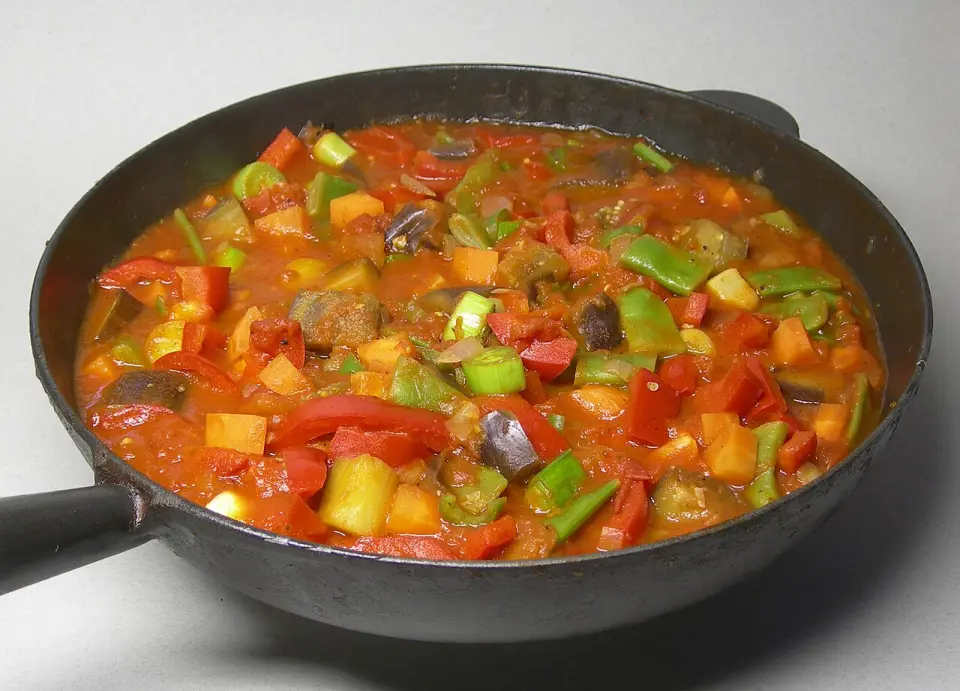 A pan of đuveč with peppers, zucchini and eggplant in tomato sauce