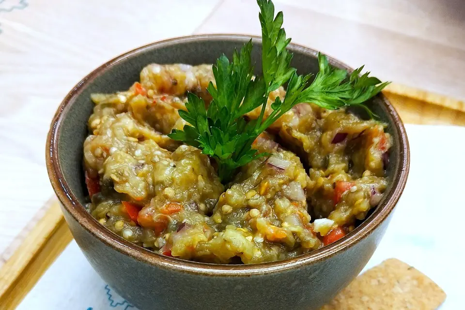 A bowl of chunky eggplant caviar with parsley, served with crackers