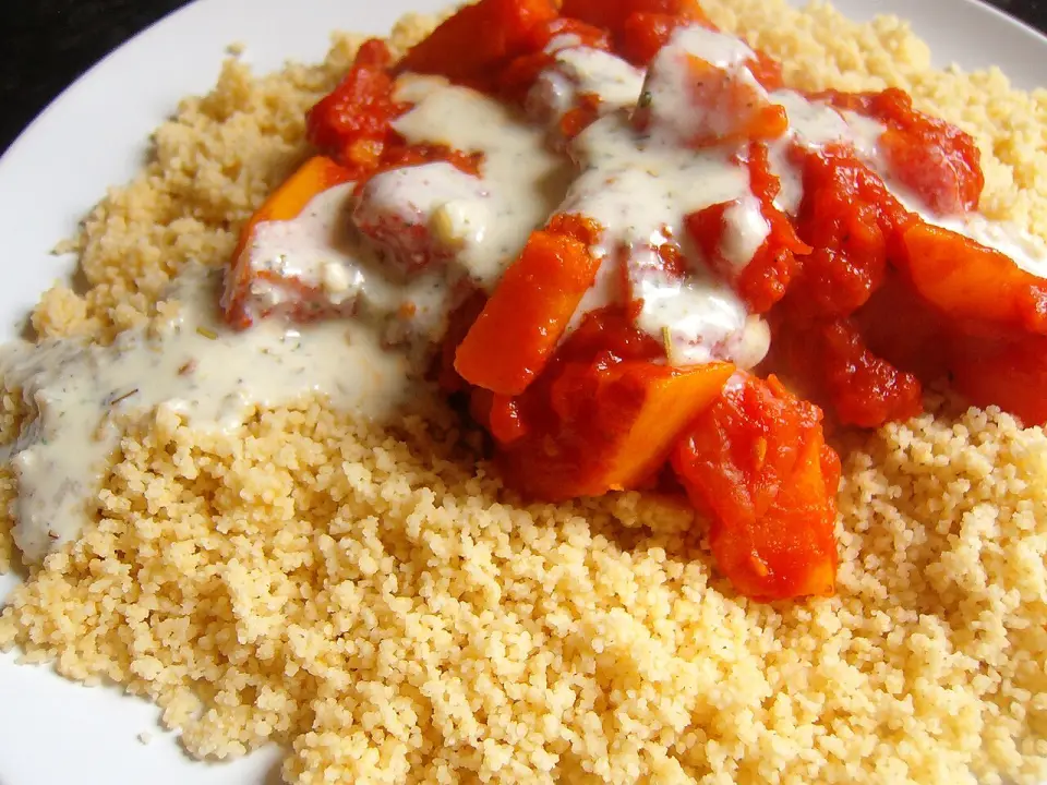 Braised pumpkin in tomato sauce with a creamy dressing over couscous