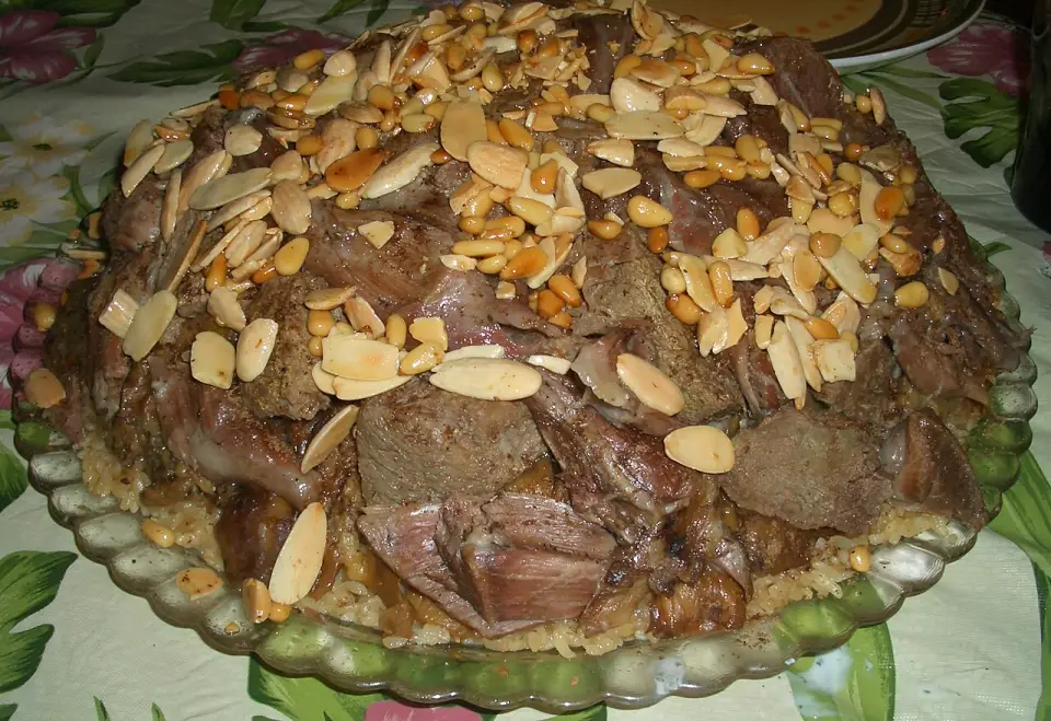 A maqluba turned out of its pot, topped with toasted almonds