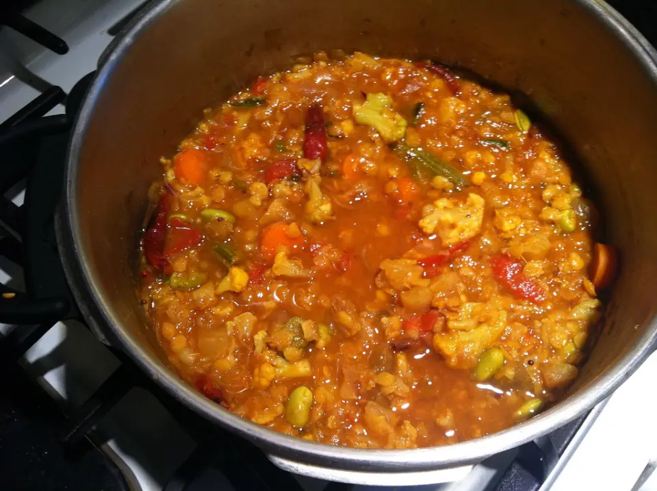 A pot of vegetable sambar with lentils, carrot and tomato